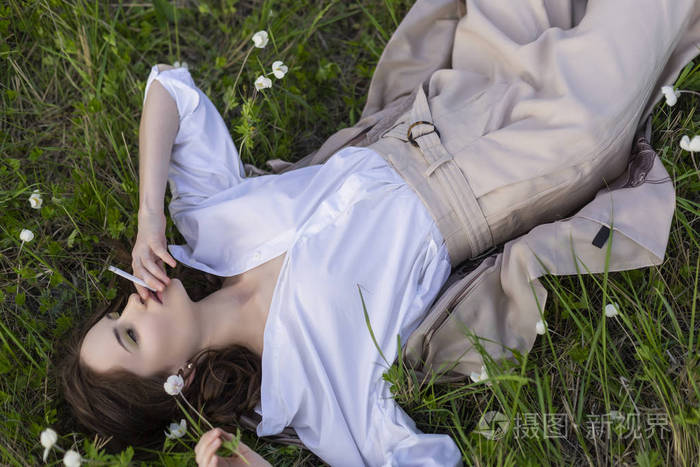 美丽时尚的年轻女孩,穿着一件时髦的白色衬衫,米色花