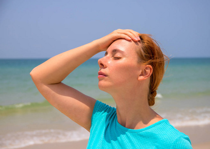 在炎热的海滩上中暑的女人. 假期的健康问题. 度假的药. 危险的太阳.