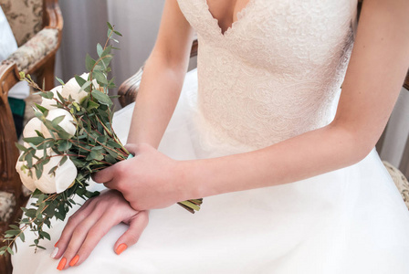 新娘穿着白色的衣服，手里拿着一束白色牡丹