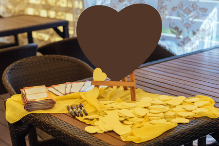 大棕色的心在桌子上，旁边的小黄色的心，为客人的愿望。 为新娘和新郎写祝福和祝贺