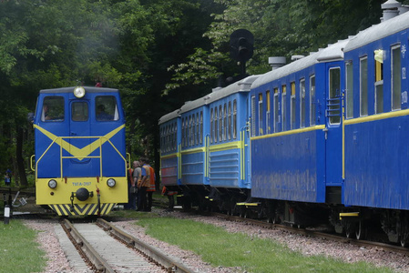 乌克兰基辅2018年5月19日火车头正在驾驶客车经过。玩具铁路。火车。火车头沿着一条窄轨铁路行驶。
