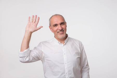 欢迎客人英俊迷人的欧洲男人挥手打招呼,同时愉快地微笑.