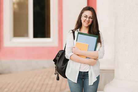 进入校园一个戴眼镜的学生女孩的肖像.