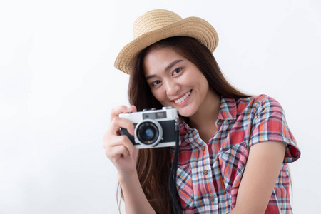 亚洲妇女正在使用电影相机拍摄白色背景的时髦女孩游客正在用电影相机拍照。