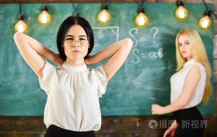 有魅力的妇女准备上课.女孩看起来很迷人, 而女士写黑板背景, 弥散.