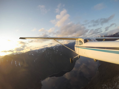 飞机飞越美丽的加拿大景观在一个充满活力和丰富多彩的日落。在加拿大不列颠哥伦比亚省温哥华附近拍摄。