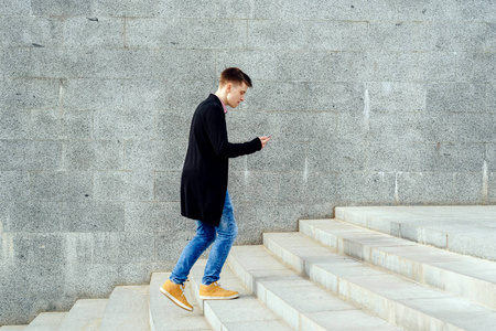 学生智能手机上楼梯自由空间一个穿着红色格子衬衫的年轻人在户外的