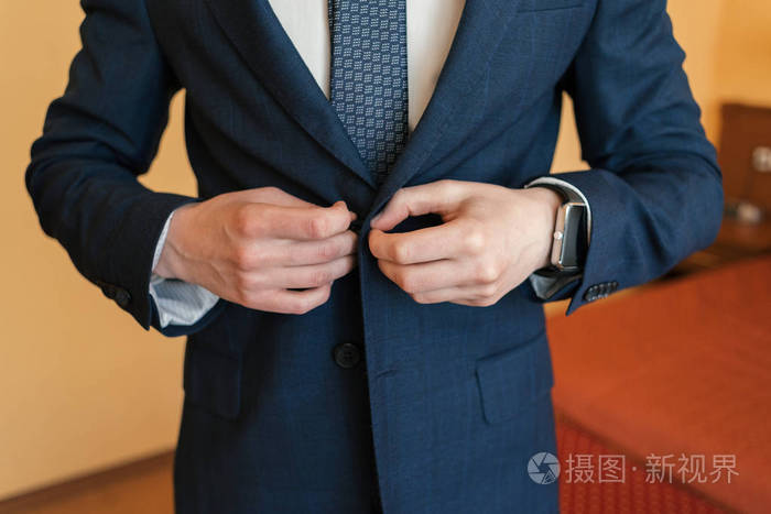 新郎把扣子系在夹克上