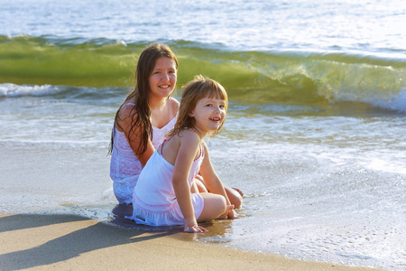 可爱的小女孩姐姐在暑假期间一起在海滩上玩漂亮的浮潜游戏