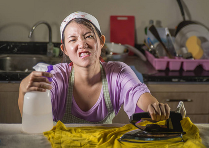 年轻漂亮的沮丧和压力亚洲的中国女人，带着熨斗在家工作，厨房熨烫衣服，绝望和不知所措在家女佣服务，家务，家务，家务压力