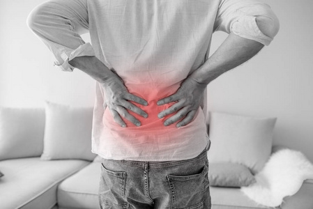 特写一个男人抱着他的背在痛苦单色照片,红色作为硬化的象征.