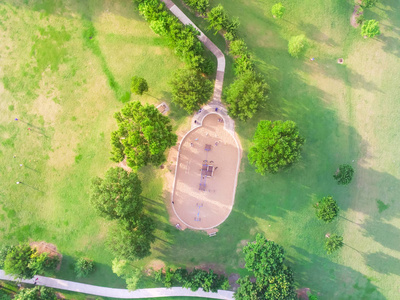 鸟瞰德克萨斯州休斯顿哈温公园的一个大孩子游戏操场。 公园里被绿色树木包围的滑梯和秋千的高架景观。 儿童户外游戏和娱乐概念。