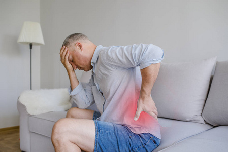 有脊柱或肾脏疼痛背痛的成熟男人的特写.