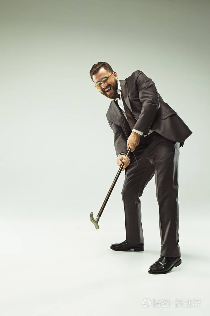 那个穿西装拿着拐杖的长胡子的人.