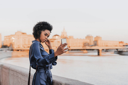  black charming girl taking selfie via her cellphone next to emb