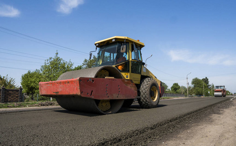 修复土壤重型振动压路机在沥青路面工作的新道路施工现场.修复照片