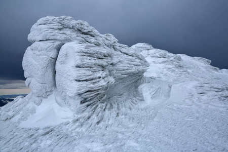 岩石冻结与有趣的纹理霜和雪，仿佛它是一个巨大的童话世界。 美丽的风景，高山，雾和阴郁的神秘天空。 地点卡帕西人。