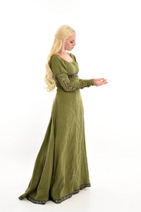 穿绿色中世纪长袍的女孩的全长肖像，站在侧面轮廓的姿势。 孤立在白色工作室背景上。