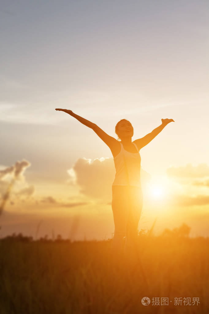 年轻女子为她的成功举起双手人生成功的概念