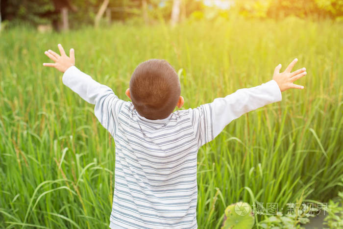 孩子举起双手看日落的天空背景.新鲜空气,环境概念