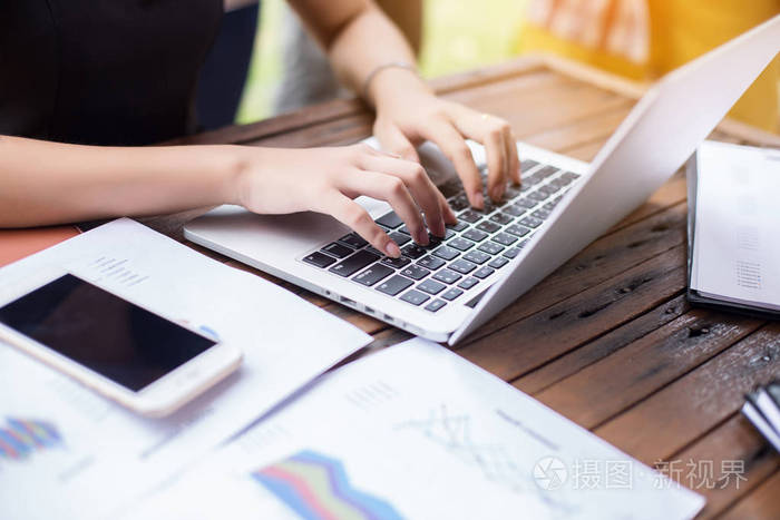 商务团队工作在笔记本电脑上而坐在办公室商业人士