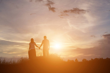 一个男人和女人手拉手一起走路的轮廓.照片