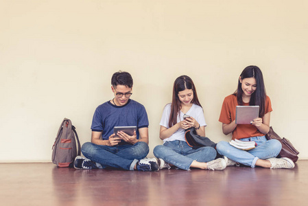 一群亚洲大学生在教室外使用平板电脑和手机。 幸福与教育学习理念。 回到学校的概念。 青少年和人的主题。 户外和技术主题。