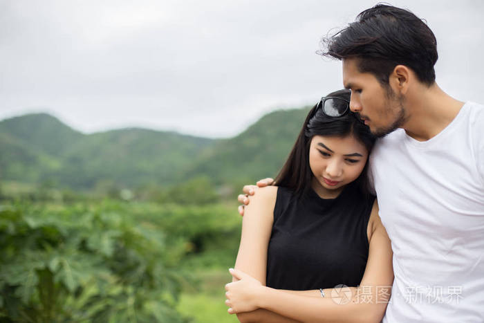 年轻英俊的男朋友拥抱他的女朋友她又伤心又难过