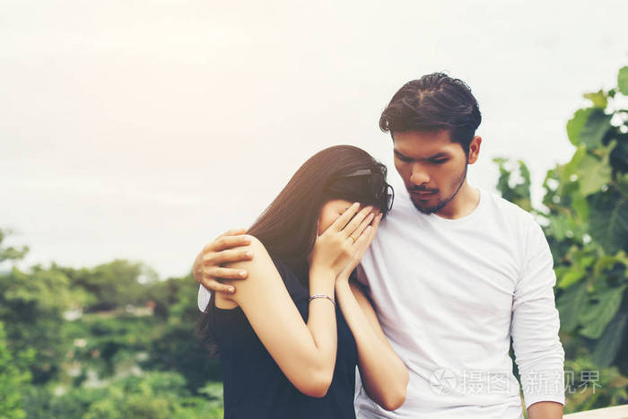 年轻英俊的男朋友拥抱他的女朋友她又伤心又难过