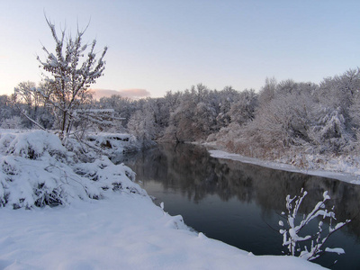美丽的冬季景观，有一条小河和树木。
