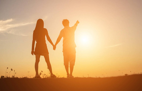 想要一个拥抱一个男人和女人手拉手一起走路的轮廓.照片