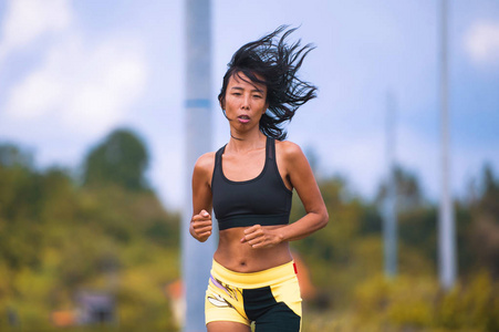 适合和运动的亚洲泰国妇女，在户外运动身体训练，在绿地景观上硬跑锻炼，在运动健身和健康的生活方式概念中慢跑锻炼