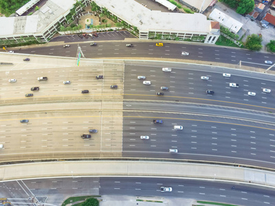 德克萨斯州休斯顿美国一条沥青高架公路的俯视图。 许多客车和卡车在下午晚些时候在高速公路上用温暖的灯光通勤。 很适合城市交通出版物