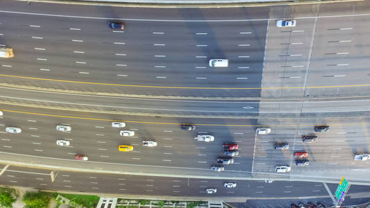 德克萨斯州休斯顿美国一条沥青高架公路的俯视图。 许多客车和卡车在下午晚些时候在高速公路上通勤，温暖的灯光。这对于城市交通出版物来