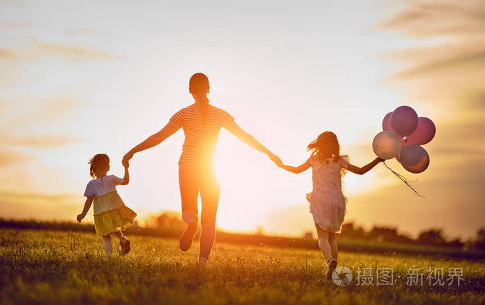 幸福的爱的家庭在夏天在大自然上玩得很开心年轻的母亲和两个女儿在