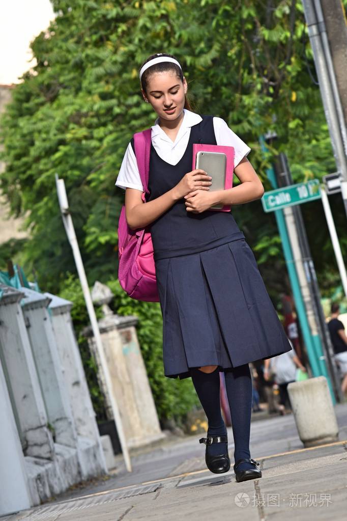 女大学生穿着制服走在人行道上