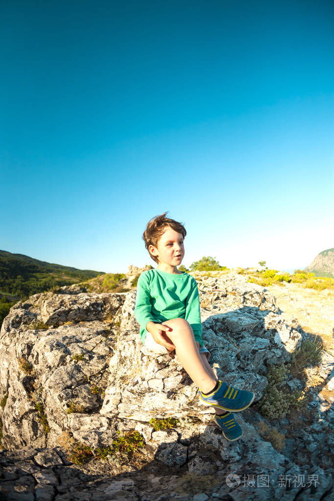 活跃的假期. 一个小旅行者坐在石头上. 攀登.