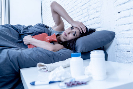 西班牙流感生病的西班牙裔妇女卧床休息,请病假,工作温度计检查发烧