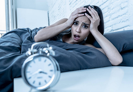 年轻美丽的西班牙裔妇女在家卧室里躺在床上,深夜试图入睡,失眠,睡眠