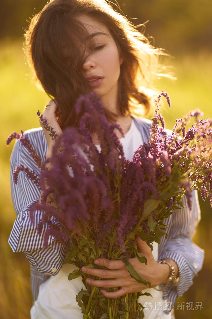 她穿着一件蓝色衬衫和一件白色t恤. 一个阳光明媚的夏天.