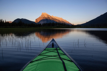 皮划艇在一个美丽的湖泊周围的加拿大山区景观。 取自朱红色湖泊班夫加拿大艾伯塔省。
