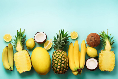 蓝色背景的新鲜有机黄色水果.单色概念与香蕉, 椰子, 菠萝, 柠檬, 瓜.