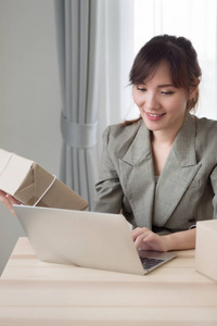  smiling woman business owner works at home or merchandise deliv