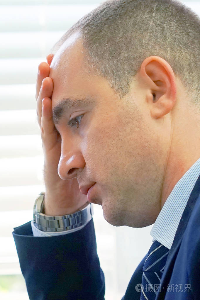 悲伤沮丧的男人坐在沙发上. 非常悲伤的商人. 孤独和痛苦的概念