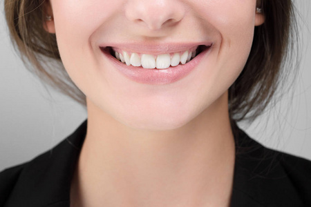 明亮的洋红色嘴唇特写快乐女性微笑与美白牙齿的美丽笑容