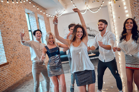 在明亮的大房间里跳舞,香槟和纸屑掉落.