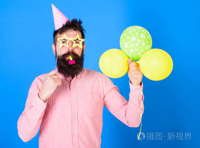 脸上留着胡子的男人拿着热气球, 蓝色的背景.惊喜的概念.