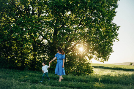 令人窒息的母亲和英俊的儿子在大自然中玩得很开心. 幸福的家庭观念.
