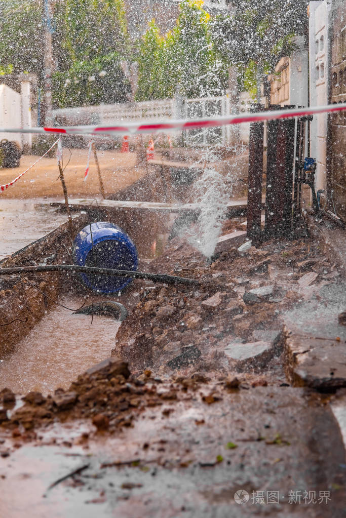 贫困街道建设和修复地下地下室后,自来水喷泉从管道泄漏的图像.