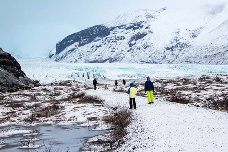 旅行者在Vatnajokull国家公园散步。 美丽的冬季景观风景。